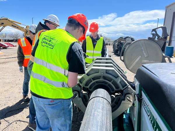 Students learn about an industrial-sized pipe in the field.