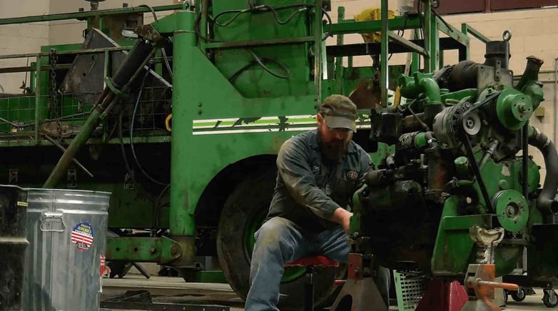 CAHill Tech. Construction worker fixes green engine.